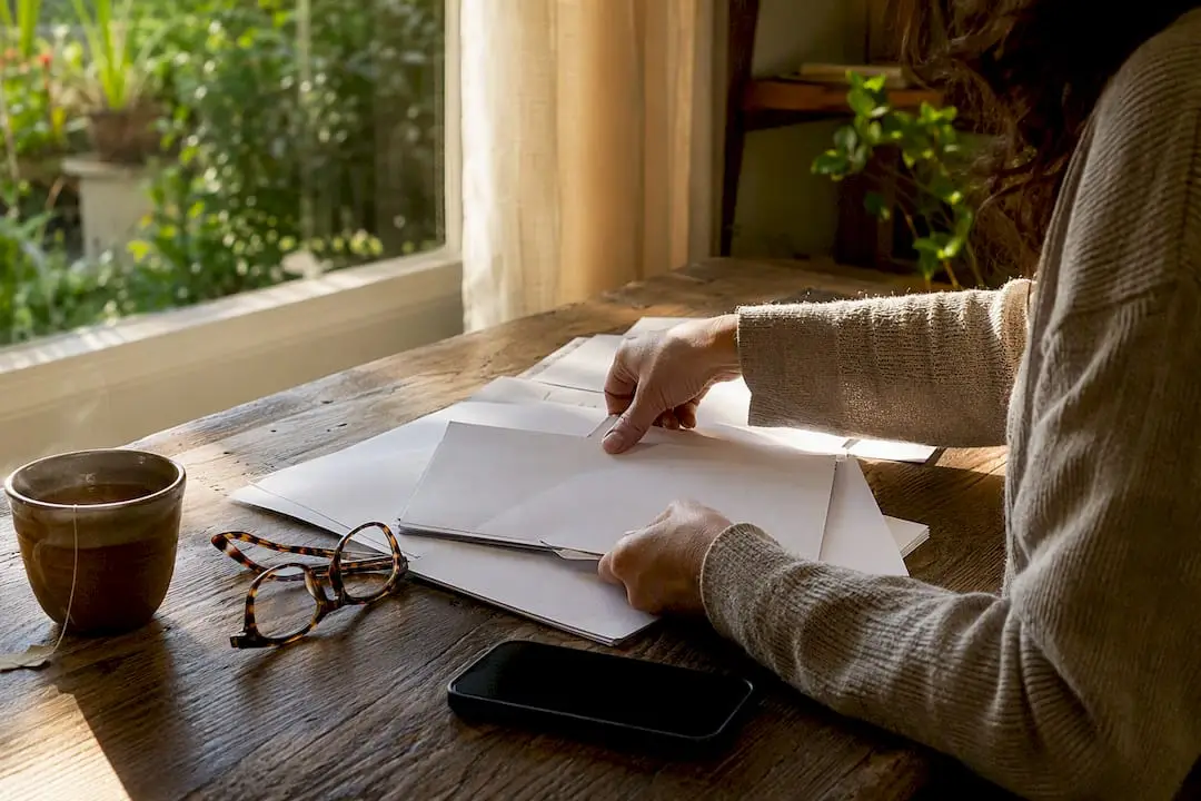 Hands organizing home loan papers on kitchen table