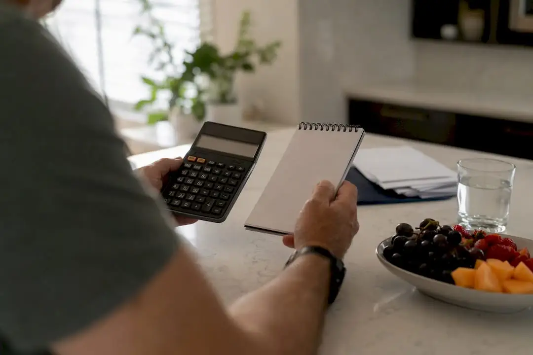 Hands with calculator and clipboard evaluating income